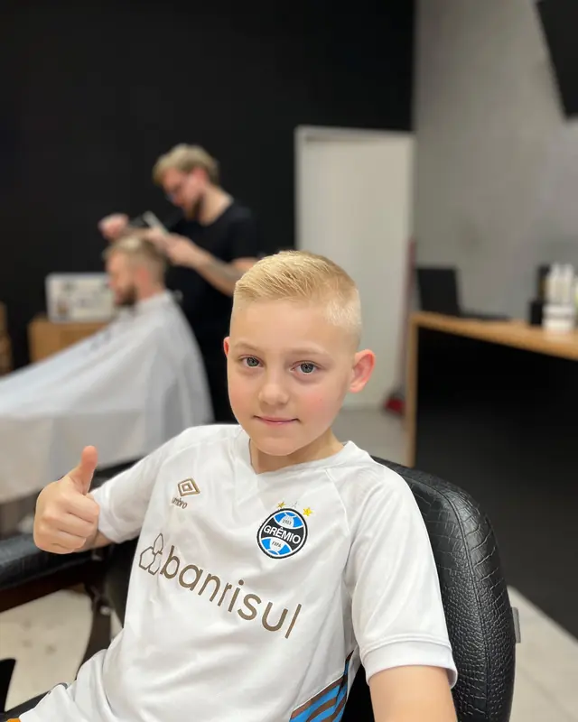 Menino fazendo sinal de positivo depois do corte