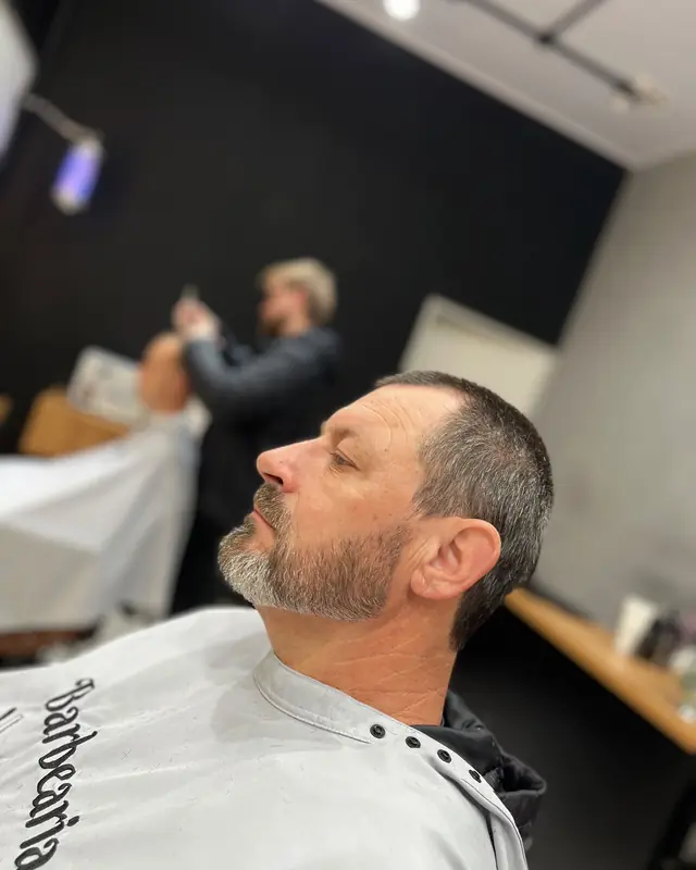 Cliente com cabelo curto e barba grisalha alinhada